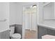 Bathroom with paneled walls, white fixtures and access to an additional storage area at 754 Centervale Dr, Kissimmee, FL 34747