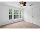 Bright bedroom features neutral carpet, a ceiling fan, and three large windows at 754 Centervale Dr, Kissimmee, FL 34747