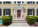 Inviting entrance with a red door, decorative wreath, manicured bushes and stone steps at 754 Centervale Dr, Kissimmee, FL 34747