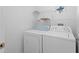 Well-lit laundry room with a washer, dryer, and shelving for extra storage at 754 Centervale Dr, Kissimmee, FL 34747