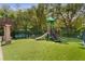 A playground with green turf and play equipment situated next to mature trees at 754 Centervale Dr, Kissimmee, FL 34747