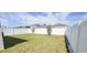 Spacious backyard with a lush lawn, surrounded by a pristine white fence, offering privacy and room to play at 853 Bocavista Ct, Davenport, FL 33896