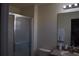 Cozy bathroom featuring a glass shower door, neutral color palette and a large vanity mirror at 8564 Bay Lilly Loop, Kissimmee, FL 34747
