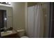 Comfortable bathroom features a shower with a curtain, a large mirror, and a single sink at 8564 Bay Lilly Loop, Kissimmee, FL 34747