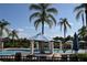 Community pool area featuring lounge chairs, palm trees, umbrellas, and beautiful landscaping at 8564 Bay Lilly Loop, Kissimmee, FL 34747