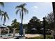 Community pool area featuring lounge chairs, palm trees, umbrellas, and a beautiful view at 8564 Bay Lilly Loop, Kissimmee, FL 34747