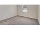A cozy bedroom with gray carpet and a bright window at 894 Pebble Crest Ln, Eagle Lake, FL 33839