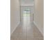 Hallway featuring tiled floors leading to a bright living area with backyard views through sliding glass doors at 894 Pebble Crest Ln, Eagle Lake, FL 33839