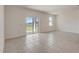 Bright living room featuring neutral walls, tile flooring, and sliding glass doors to the backyard at 894 Pebble Crest Ln, Eagle Lake, FL 33839