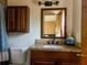Bathroom vanity with granite counters, wood cabinets and brushed bronze fixtures at 909 Royalton Rd, Orlando, FL 32825