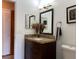 Bathroom vanity with granite counters, wood cabinets, brushed bronze fixtures and nice decor at 909 Royalton Rd, Orlando, FL 32825