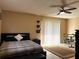 Bedroom with comfortable bed, black furniture, light neutral decor and sliding glass door at 909 Royalton Rd, Orlando, FL 32825