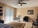 Comfortable bedroom with fan, exercise bike, chair, neutral decor and view to the sliding glass door at 909 Royalton Rd, Orlando, FL 32825