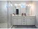 Modern bathroom features a double vanity, a glass enclosed shower and great natural light at 9443 Merrifield St, Orlando, FL 32827