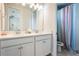 Bathroom featuring a double vanity with white cabinetry and a glass-enclosed shower with modern fixtures at 9443 Merrifield St, Orlando, FL 32827