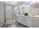Bright bathroom featuring a walk-in shower with glass doors and a double sink vanity at 9443 Merrifield St, Orlando, FL 32827