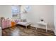 Bright bedroom with hard floors, two large windows and a -sized bed, desk and dresser at 9443 Merrifield St, Orlando, FL 32827