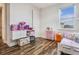 This bedroom features hard floors, a large window and a cute storage unit for a  at 9443 Merrifield St, Orlando, FL 32827