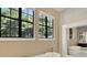 Bright bathroom features a soaking tub, beige walls, and a view to the outside through beautiful windows at 9743 Covent Garden Dr, Orlando, FL 32827