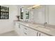 Bright bathroom featuring double sinks, white cabinetry, quartz counters, and a frameless glass shower at 9743 Covent Garden Dr, Orlando, FL 32827