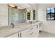 Bright bathroom featuring double sinks, white cabinetry, quartz counters, and a frameless glass shower at 9743 Covent Garden Dr, Orlando, FL 32827