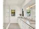 Bright bathroom showcasing double sinks, white cabinetry, quartz counters, and a frameless glass shower at 9743 Covent Garden Dr, Orlando, FL 32827