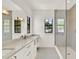 Elegant bathroom showcasing double sinks, white cabinetry, quartz counters, and frameless glass shower at 9743 Covent Garden Dr, Orlando, FL 32827