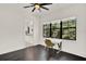 Bedroom featuring dark hardwood floors, a ceiling fan, and large window with a view of nature at 9743 Covent Garden Dr, Orlando, FL 32827