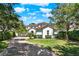 Beautiful two-story home with a well manicured lawn, lush landscaping, and brick paved driveway at 9743 Covent Garden Dr, Orlando, FL 32827