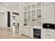 Hallway view of a kitchen showcasing custom cabinetry, beverage cooler, and view of living space at 9743 Covent Garden Dr, Orlando, FL 32827