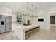 Spacious kitchen featuring white cabinetry, a stainless steel refrigerator, and a large island with stool seating at 9743 Covent Garden Dr, Orlando, FL 32827