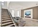 Modern living room with sleek staircase, large TV, and stylish gray sofa at 9743 Covent Garden Dr, Orlando, FL 32827