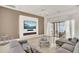 Bright living room features a modern fireplace, comfortable gray seating, and access to the outdoor patio at 9743 Covent Garden Dr, Orlando, FL 32827