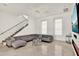 Spacious living room featuring a staircase, gray sectional sofa and large windows for ample natural light at 9743 Covent Garden Dr, Orlando, FL 32827