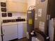 Laundry room including washing machine, dryer, and water heater with tan cabinets at 207 Esplanade Way # 101, Casselberry, FL 32707