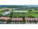 Aerial view of townhomes with a golf course, lake and pristine landscaping at 10533 Belfry Cir, Orlando, FL 32832