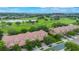 Aerial view of townhomes near a golf course and a lake within a green landscape at 10533 Belfry Cir, Orlando, FL 32832