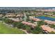Sprawling aerial of community with red-tiled roofs, lush greenery, golf course and serene lake at 10533 Belfry Cir, Orlando, FL 32832