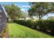 Lush green backyard featuring manicured landscaping, mature trees, and a serene outdoor space for recreation and relaxation at 10533 Belfry Cir, Orlando, FL 32832