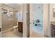 Well-lit bathroom showcasing a glass-enclosed shower, neutral-toned tiling, and office view at 10533 Belfry Cir, Orlando, FL 32832