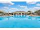Large community pool with ample seating and umbrellas; a serene setting for relaxation and leisure at 10533 Belfry Cir, Orlando, FL 32832