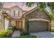 Charming home showcasing stone accents, a two-car garage, and a beautifully landscaped front yard at 10533 Belfry Cir, Orlando, FL 32832