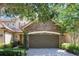 Inviting townhome with a stone-accented facade, a two-car garage, and a charming landscaped entry at 10533 Belfry Cir, Orlando, FL 32832