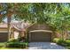 Attractive townhome featuring stone accents, a two-car garage, and mature landscaping at 10533 Belfry Cir, Orlando, FL 32832