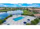 Stunning aerial view of the community pool and lounging area with lush landscaping near a tranquil pond at 10533 Belfry Cir, Orlando, FL 32832