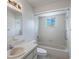 A clean white bathroom features tiled walls, bathtub with shower and a window offering natural light at 10980 Sw 62Nd Ave, Ocala, FL 34476