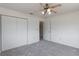 This carpeted bedroom features a ceiling fan and a closet with ample storage at 10980 Sw 62Nd Ave, Ocala, FL 34476