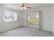 Carpeted bedroom with a ceiling fan has a sliding glass door that leads to a screened-in patio at 10980 Sw 62Nd Ave, Ocala, FL 34476