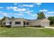 Well-kept single-story home with a green lawn and attached two-car garage, with windows and shrubbery at 10980 Sw 62Nd Ave, Ocala, FL 34476