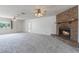 Bright living room with a brick fireplace, neutral carpet, and large windows at 10980 Sw 62Nd Ave, Ocala, FL 34476